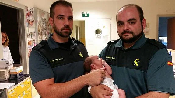 Los agentes de la benemérita Carlos y Andrés sujetan al bebé. 