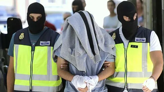 Agentes de la Policía Nacional conducen a un supuesto yihadista.  