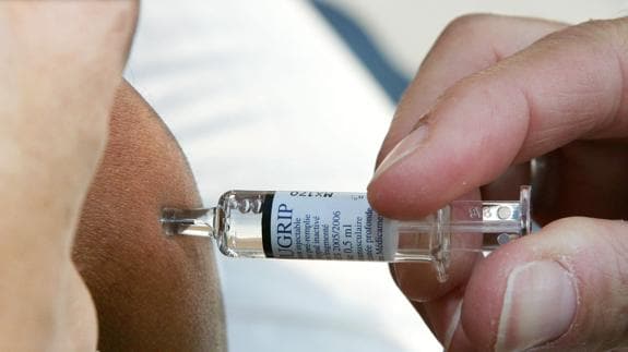 Un médico francés vacuna a un paciente contra la gripe.