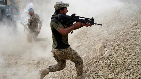 Soldado iraquí corre hacia su posición de tiro