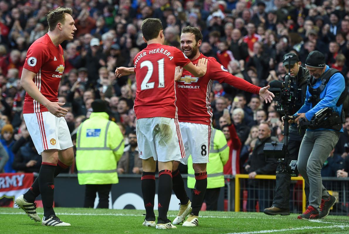 Ander Herrera felicita a Juan Mata delante de Phil Jones. 