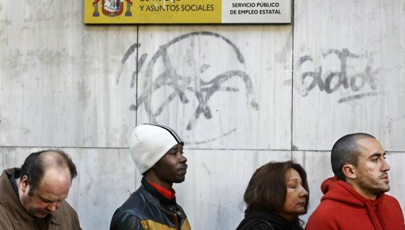 Varias personas hacen cola ante la oficina del INEM en Madrid .