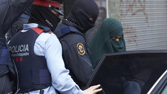 Los Mossos salen con la joven detenida de 19 años en el marco de una operación contra el terrorismo yihadista en Terrassa. 