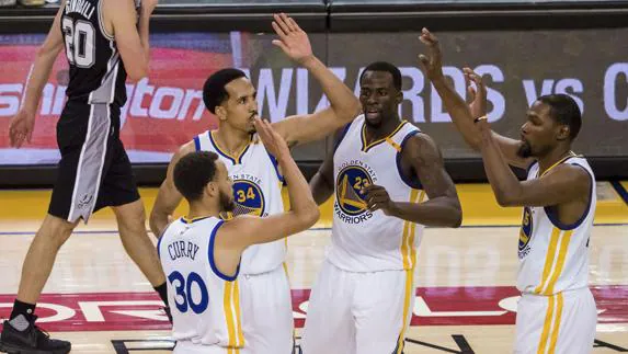 Los jugadores de los Warriors celebran una canasta de Stephen Curry (i).
