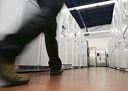 Un cliente camina por un pasillo entre frigoríficos en una tienda de electrodomésticos. :: IDEAL