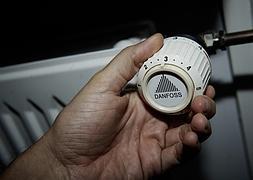 Un hombre regula el radiador de la calefacción de una casa. / AP