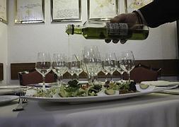 Un camarero aliña una ensalada con aceite de oliva de una botella irrellenable. :: RAMÓN L. PÉREZ