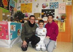 Javier posas con sus padres, Javier y Belinda, en las instalaciones del colegio. :: I. SÁNCHEZ