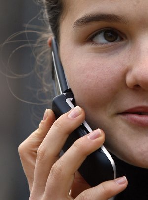 Una joven habla por el teléfono móvil. / AFP