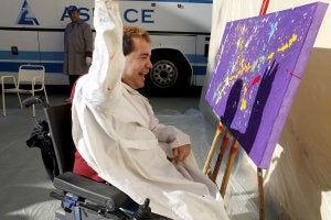 Jesús Moraga lanza pintura sobre el lienzo para contribuir a un cuadro que les ha encargado un cliente. / JOSÉ CARLOS MALDONADO