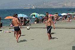 Varios jóvenes juegan descalzos en la arena de una playa de Almería. :: IDEAL