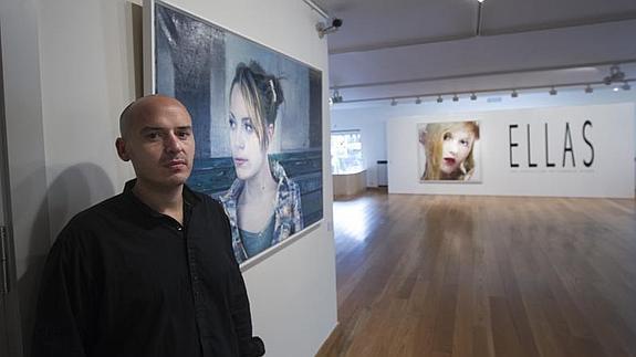 Eugenio Ocaña posa ante algunos de sus cuadros de la exposión 'Ellas' 