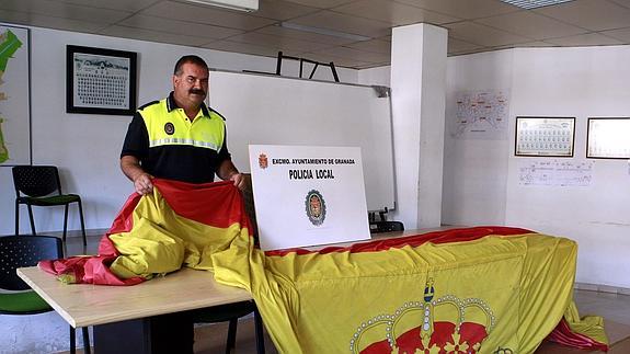 Un agente de Policía Local, con la bandera tras su robo en 2009. / IDEAL