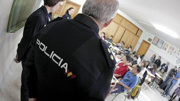 Policías nacionales ofrecen una charla sobre drogas en un centro educativo. 
