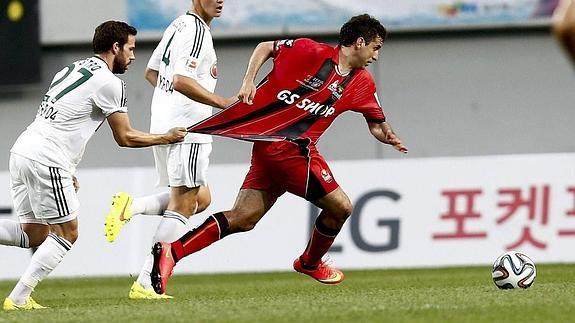 El jugador del equipo alemán Bayer Leverkusen Gonzalo Castro (i) disputa un balón ante el jugador del equipo surcoreano FC Seúl Sergio Escudero (d).