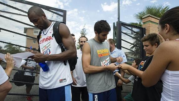 El pívot de la selección española de baloncesto Serge Ibaka y el base Ricky Rubio, firman autógrafos tras finalizar el entrenamiento en el pabellón Núñez Blanco en Granada ayer.