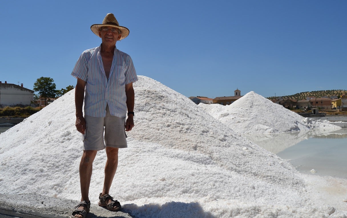 Enrique Lorenzo Villegas, fotografiado junto a dos pequeños montículos de la mejor sal que se obtiene en La Malahá.