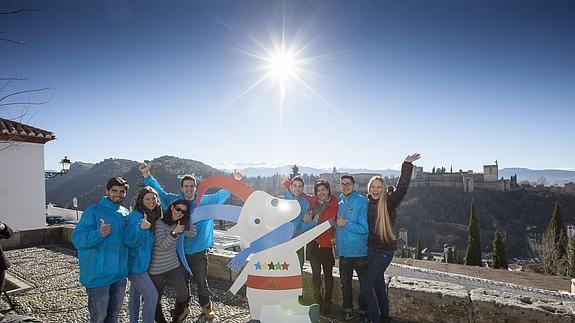 Un grupo de voluntarios acompañados de la esquiadora María José Rienda posan junto a Uggi, mascota de la Universiada. 