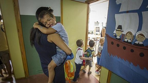 Uno de los alumnos más pequeños del colegio Genil se abraza a su madre antes de entrar en el aula.