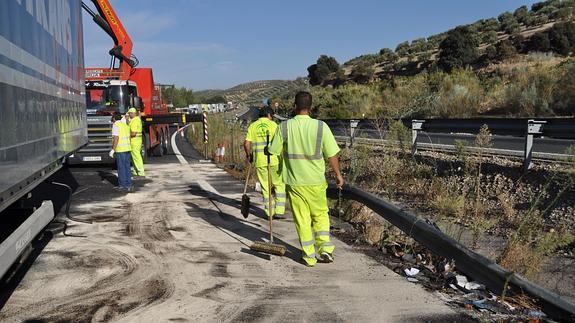 Operarios limpian la calzada de la A-92, tras el accidente en Salar