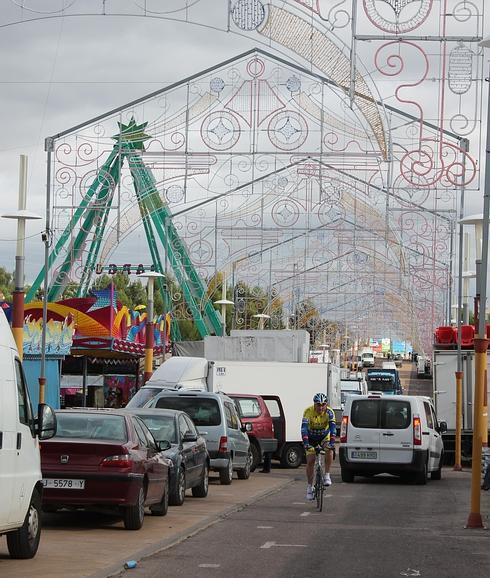 Un ciclista pasea por la calle central del ferial mientras las casetas ultimaban preparativos. 