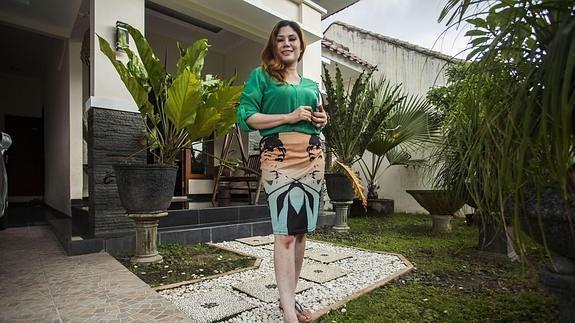 Wina Lia posa a la entrada de su casa. Una vivienda con jardín, dos baños y un estanque con peces.