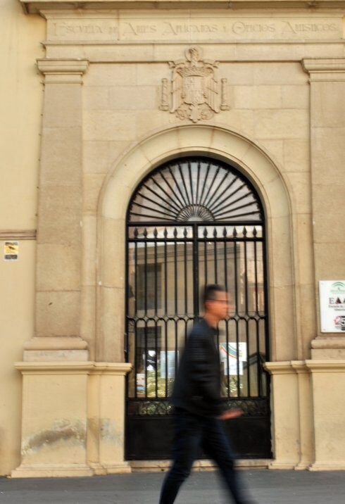 Un ciudadano pasea ante la entrada de la Escuela de Artes. 