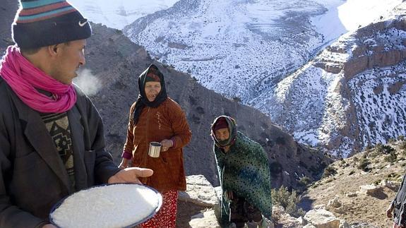 Una familia bereber, con un plato de comida en el Alto Atlas, donde viven al refugio de las rocas.