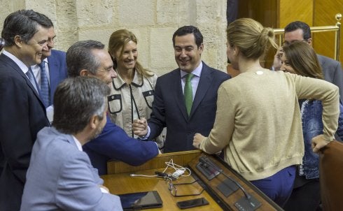 Juanma Moreno conversa con diputados de su grupo.