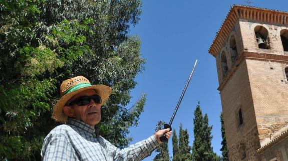 Un vecino señala la torre del campanario.