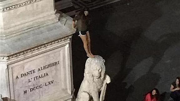 Imagen de la turista encaramada a la escultura de Dante en la plaza de la Santa Croce. 
