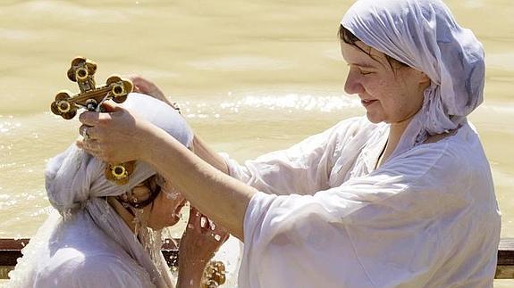 Dos peregrinas ortodoxas se bautizan en las aguas del río Jordán. 