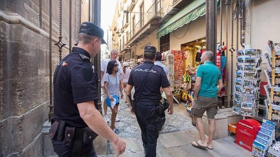 Una pareja de agentes de la Policía Nacional patrulla junto a la Catedral de Granada