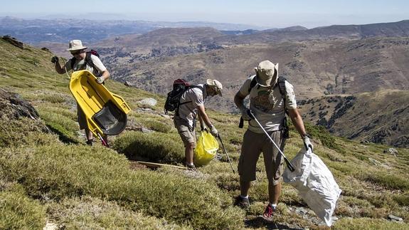 Enrique y Juanma se aplican en la recogida de basura en las altas cumbres de Sierra Nevada. 
