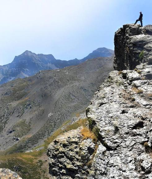 Sobre las rocas de los Peñones de San Francisco, se observa la cuerda de los 'tresmiles' con el Mulhacén y la Alcazaba a la izquierda.