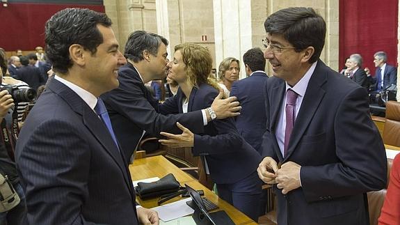 El presidente del PP andaluz, Juanma Moreno, conversa con el portavoz de C's, Juan Marín, en el Parlamento el pasado junio.