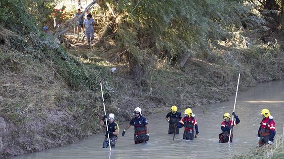 Operarios de Protección Civil y Bomberos buscan a un desaparecido en la riada de Deifontes del 29 de agosto de 2013.