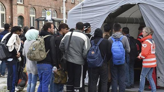 Refugiados sirios hacen cola en una tienda de campaña de la Cruz Roja en Alemania