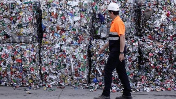 Un técnico de la planta de reciclaje de Alhendín pasea delante de varios paquetes de residuos ligeros.
