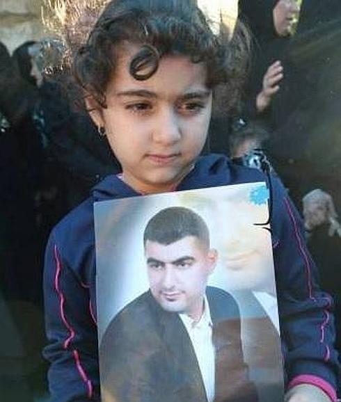 La hija de Adel posa con una foto de su padre, rindiéndole homenaje.