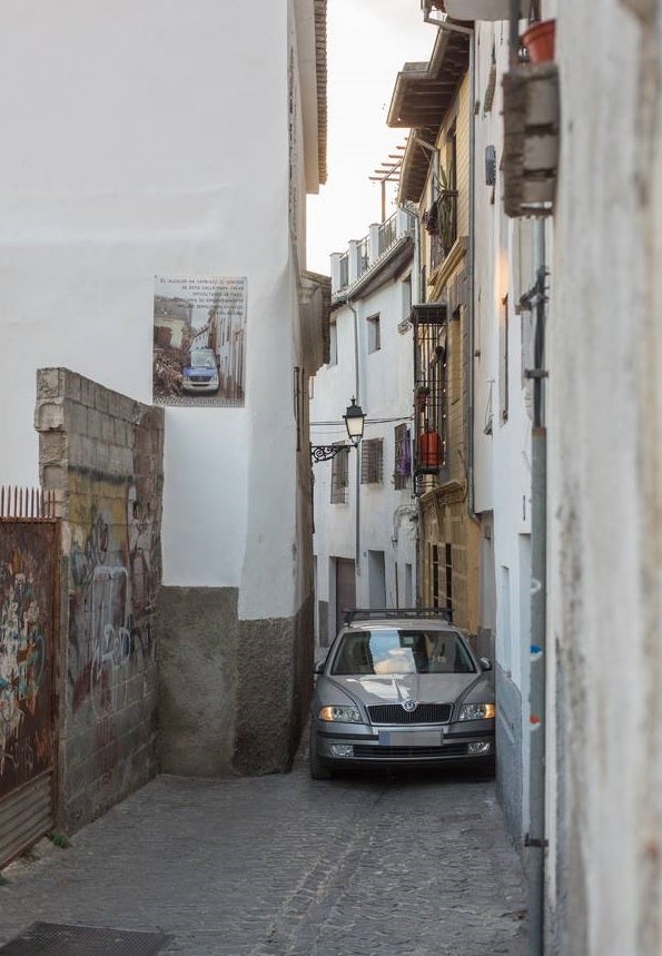 Un coche maniobra en la calle San Juan de los Reyes para superar las angosturas de esta vía. :