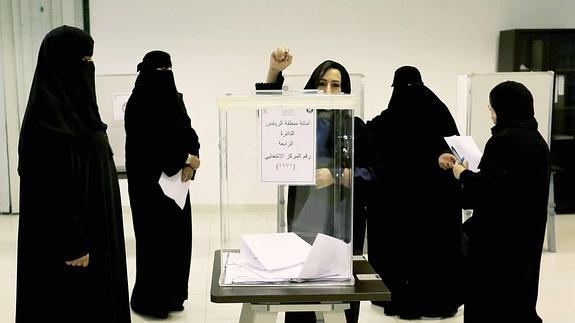 Mujeres cubiertas con ‘niqab’ y ‘abaya’ negra votan el sábado pasado, por primera vez en la historia de Arabia Saudí. :: 