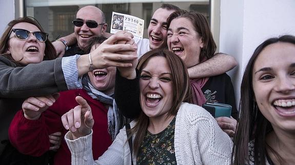 Agraciados muestran un décimo del número 79.140, en el que ha recaído el Gordo del sorteo extraordinario de la Loteria de Navidad.
