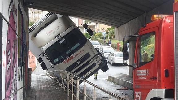 Imagen del camión encajado bajo el puente. 