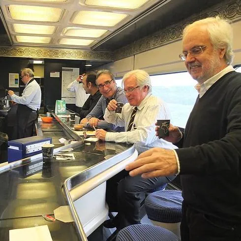 Miembros de la Mesa del Ferrocarril degustan un café durante el largo trayecto en la cafetería del tren. 