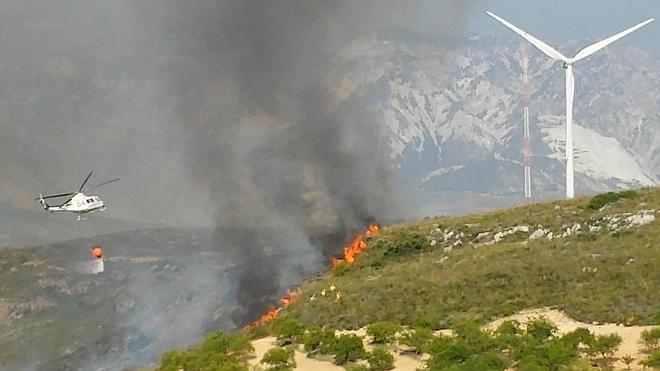 Un helicóptero sofoca el fuego. 