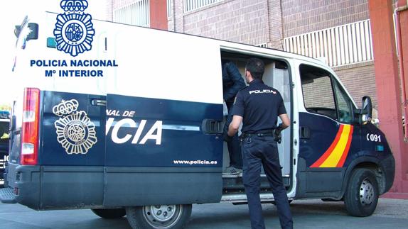 Un agente introduce a un detenido en un furgón policial en la Comisaría Provincial.