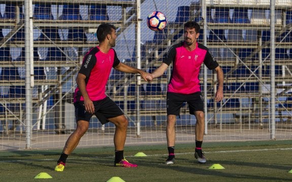 Barral (i) y Cuenca comparten ejercicio durante un entrenamiento con el Granada.