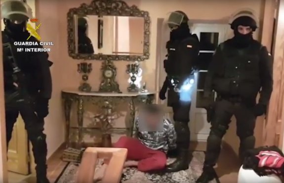 Agentes de la Guardia Civil custodian a uno de los presuntos yihadistas en una vivienda situada en Coruña.