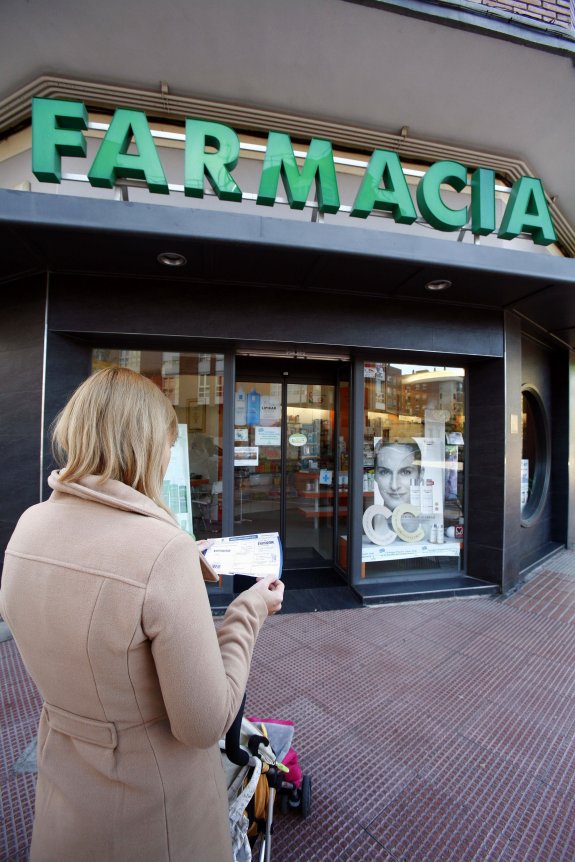 Una mujer se dispone a entrar en una farmacia. A la derecha, las informaciones que publicó IDEAL sobre la trama.